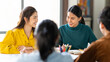 © Urbanscape - Group of young Asian business people or creative team in brainstorm discussion meeting in office. Female coworker leading team talk. Business teamwork, happy work, or colleague partnership concept
