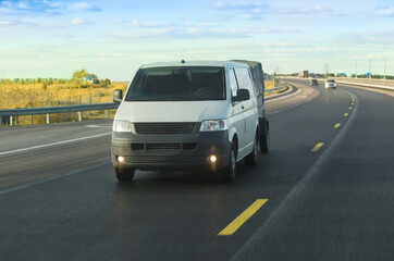 Canvas Print - minivan with trailer moves along road