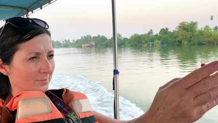 woman on a boat tour taking images with her smartphone