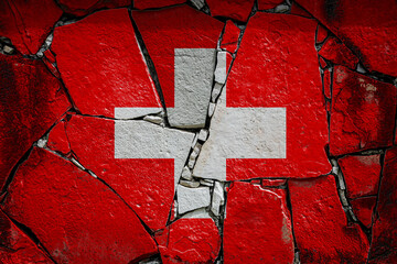 National flag of Switzerland depicting in paint colors on an old stone wall. Flag  banner on broken  wall background.