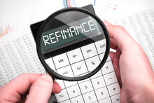 The Word Refinance Is Written On The Calculator. Business Man Holding A Calculator In His Hand.