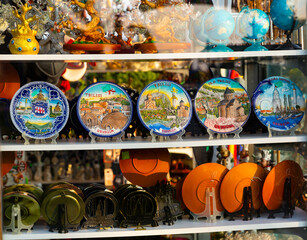 Wall Mural - Showcase of traditional Georgian souvenir shop with various colorful hand-painted ceramic plates, original decorative minifigures, picture frames, cups on shelves. Travel memories concept