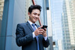© Timeimage - Young Asian businessman using smartphone to text message