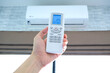 © Photo Sesaon - Man's hand using remote control open The air conditioner is cooled to 25 degrees Celsius in his bedroom. Health concepts and energy savings