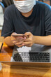 © Quang - People wearing protective mask while using smartphone and laptop