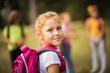 © liderina - Large group of school kids in nature. Portrait of school girl. Focus is on foreground.  It's time for a little fun after school.