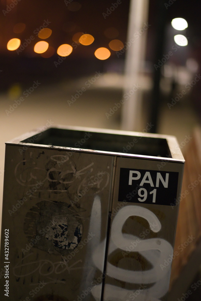 Empty trash can with painted scribbles and blurred bokeh background. - obrazy, fototapety, plakaty 
