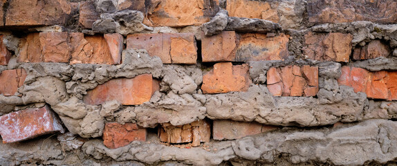 Wall Mural - Demolished stone wall with exposed bricks, red, cracked and damaged brick wall