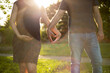 Eine junge schwangere Frau und ein Mann formen mit Ihren Händen ein Herz. Gegenlichtaufnahme