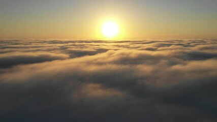 Wall Mural - striking aerial view of the sunset sky with the clouds below us. the shadows projected from the sun 