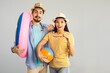 © Studio Romantic - Pleasantly surprised married couple standing with an inflatable circle and a ball on a gray background. Concept of positive human emotions, people and summer vacation. Banner. Place for text.