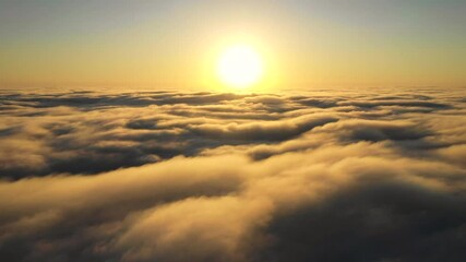 Wall Mural - striking aerial view of the sunset sky with the clouds below us. the shadows projected from the sun 