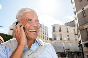 Wall Mural - man smiling and talking with mobile my-one in city