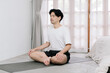 © Gengwit - Asian young man doing yoga at home