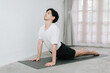 © Gengwit - Asian young man doing yoga at home