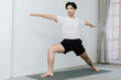© Gengwit - Asian young man doing yoga at home