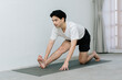 © Gengwit - Asian young man doing yoga at home