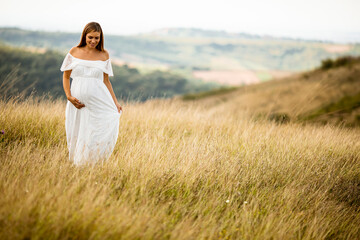 Young pregnant woman at the field