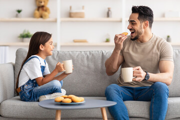 Wall Mural - Cheerful little daughter and dad having breakfast