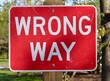 A close view of the wrong way sign.