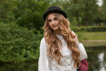 Canvas Print - Young happy woman student in black hat outdoors