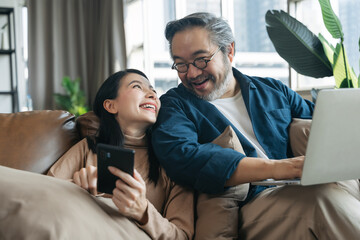 Female showing smartphone to husband in living room at home