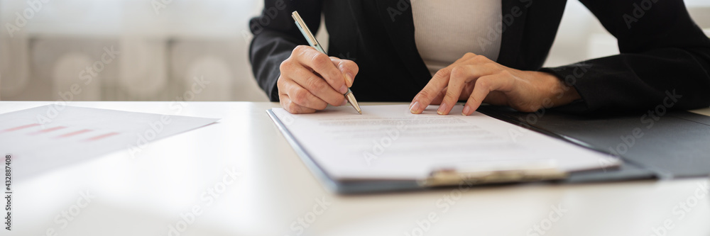 Businesswoman signing a document or application form in a folder - obrazy, fototapety, plakaty 