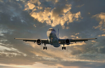 the plane is flying in the sky at sunset