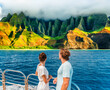 © Maridav - Hawaii Kauai Na Pali coast landscape scenic cruise. Couple watching dramatic mountains famous tourist destination on boat deck. Cruise ship on summer travel vacation and woman tourists relaxing.