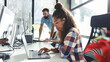 © BalanceFormCreative - Young female programmer sitting at the desk in her office and working .