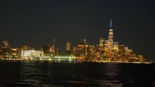 View From Boat Ride Of City Skyline Of Manhattan On Summer Evening With Lights On World Trace Center