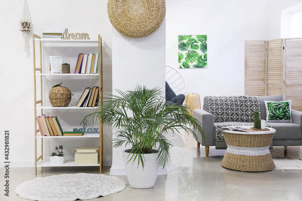 Shelf unit with books and sofa in interior of room