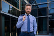 © Volodymyr - Executive businessman. Portrait of ceo near modern office in suit. Happy leader standing in front of company building.