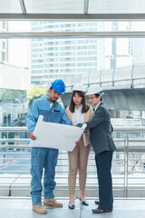 Civil engineer teams meeting working together wear worker helmets hardhat on construction site in modern city. Foreman industry project manager engineer teamwork. Asian industry professional team