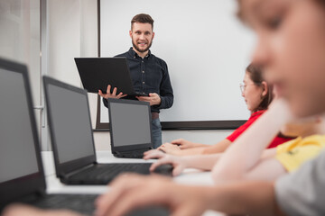 Wall Mural - company of children using laptops during lesson
