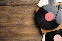 Modern Player And Vinyl Records On Wooden Background, Flat Lay. Space For Text