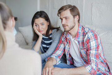 Young couple talking about their problem with psychologist in office.