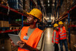 © bernardbodo - Warehouse worker using digital tablet looking up at tall shelves
