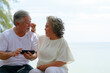 © sutthichai - Happy Asian senior couple enjoy playing smartphone outdoor. Retirement and love concept.