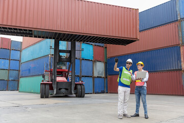 Foreman is working in a port with a container. businessman and Foreman control loading Containers from Cargo.