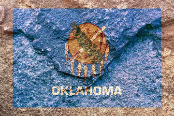 Faded Oklahoma state flag icon pattern isolated on weathered solid rock wall background