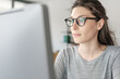 © StockPhotoPro - Woman with glasses working on a computer
