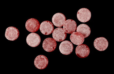 Wall Mural - Sour cherry bonbons, candy pile isolated on black background, top view