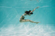 © LIGHTFIELD STUDIOS - graceful young woman in swimsuit swimming in pool