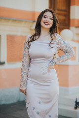 Wall Mural - Vertical shot of a smiling Caucasian female with beautiful dress posing outdoors