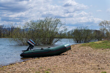 On A Sunny Day, There Is An Inflatable Boat With An Engine On The Shore Of The Lake.