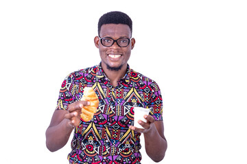 handsome young man holding croissant bread and milk smiling.