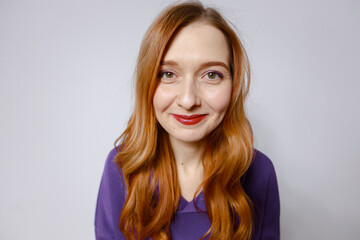 Funny redhead girl in purple hoodie. White background