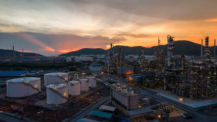 Wall Mural - Chemical oil refinery plant, power plant and metal pipe on sunset sky background.