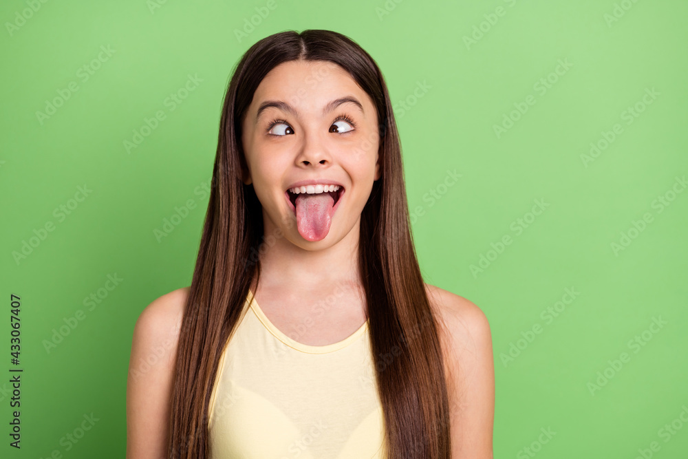 Portrait of excited carefree person squint eyes tongue out have fun isolated on green color background - obrazy, fototapety, plakaty 